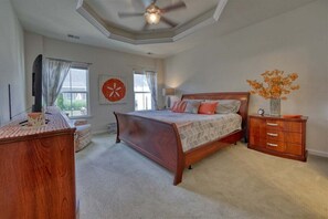 Une chambre à coucher avec un lit, une commode et un ventilateur de plafond.