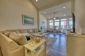 A spacious living area with a large sofa, a coffee table, and a television.