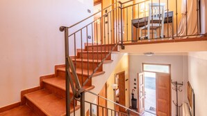 A staircase with a metal railing leading to a second floor.