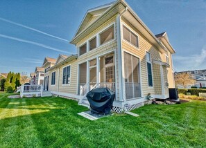 A two-story house with a porch, a covered grill, and a well-maintained lawn. - Bayside * 4 BR Luxury House (Selbyville)