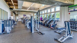 Un gimnasio con cintas de correr, máquinas de pesas y mancuernas.