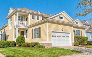 A two-story house with a front porch, a garage, and a well-maintained lawn. - Bayside * 4 BR Luxury House (Selbyville)