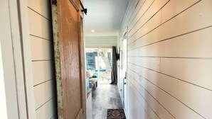 A narrow hallway with wooden walls and a door leading to a room. - Dog friendly! - #11 is 1 of 3 containers now dog friendly! (Blanco County)