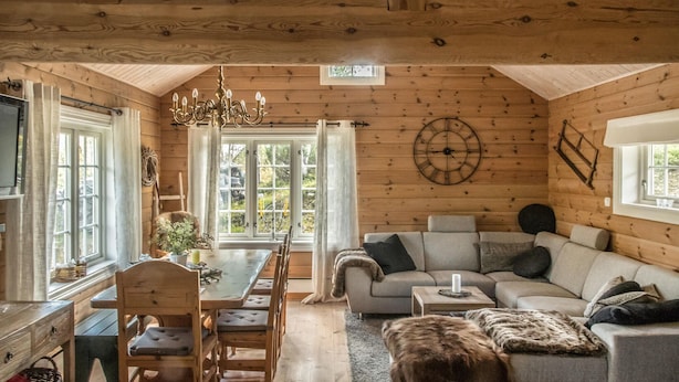 A cozy cabin interior with a dining area, a sofa, and a dog. - 3 bedroom nice home in Oppdal (Oppdal)