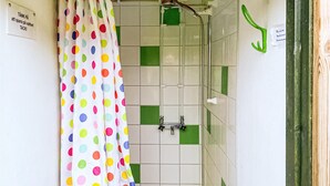 A bathroom with a shower, a white tiled wall, and a colorful polka dot curtain. - Nice home in Visby with WiFi (Visby)