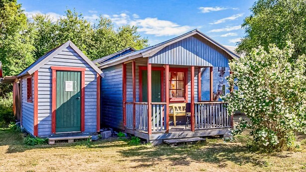 Two small, single-story cabins with a porch, surrounded by greenery. - Nice home in Visby with WiFi (Visby)