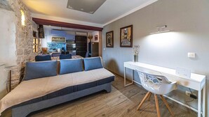 Una sala moderna con un sofá, una mesa de comedor y una cocina al fondo.