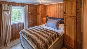 A wooden-paneled bedroom with a bed, curtains, and a window. - Awesome home in Hemsedal with WiFi (Hemsedal)