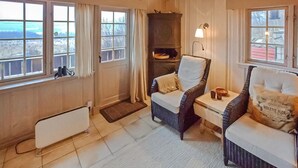 A cozy room with two wicker armchairs, a small table, a radiator, and a window with curtains. - Awesome home in Hemsedal with WiFi (Hemsedal)