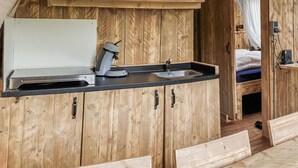 A compact kitchen with wooden cabinets, a sink, and a countertop.