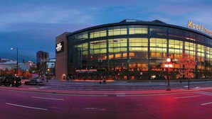 Un edificio moderno con facciata in vetro curvo, con la scritta "Xcel Energy Center".