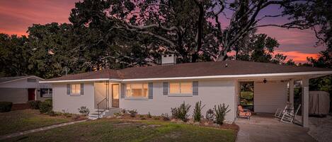 A single-story house with a covered porch, a visible garage, and a well-maintained lawn.