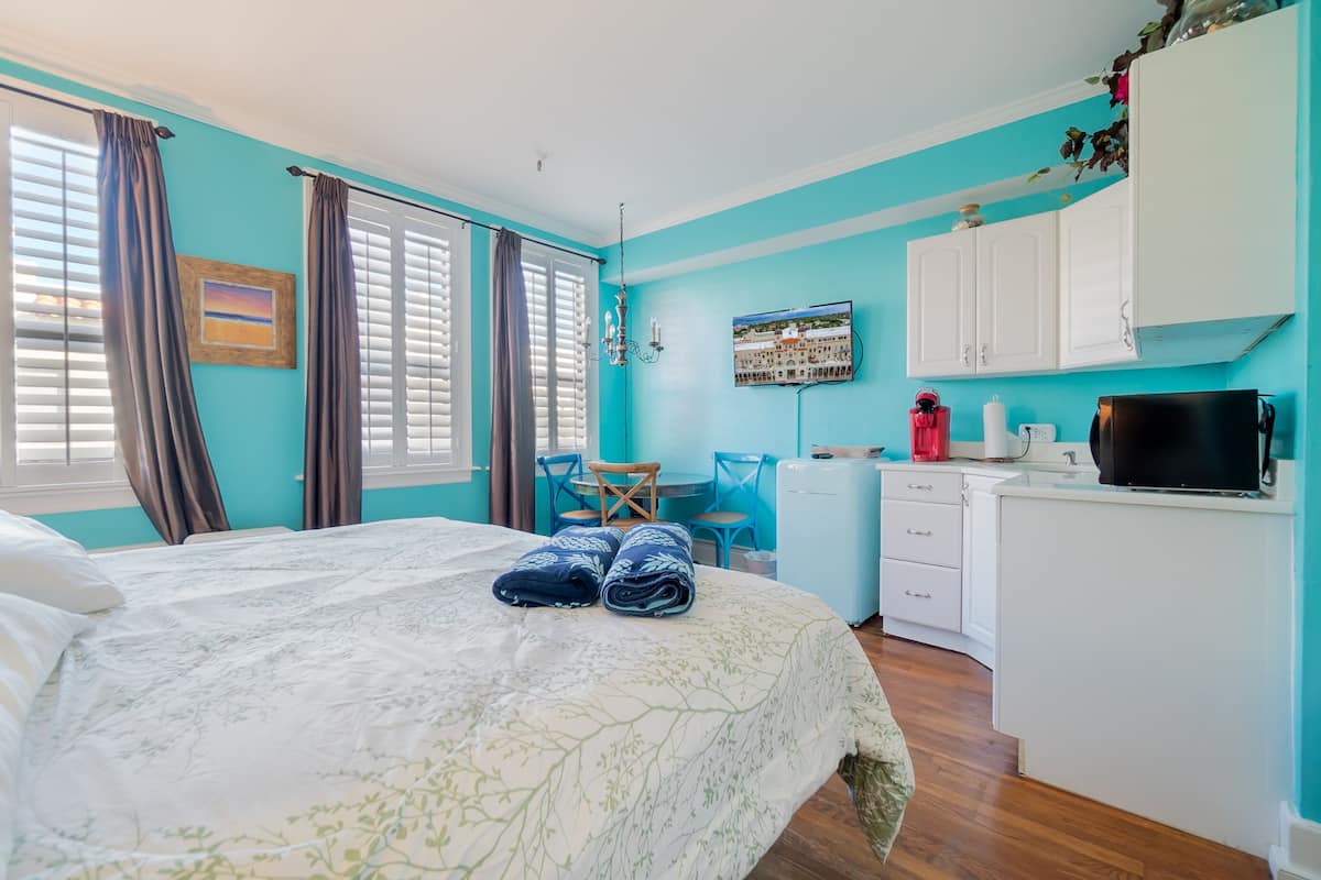A bedroom with a bed, a desk, and a chair.