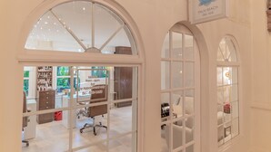 Een wellnessruimte met boogvensters, een receptiebalie en een zichtbaar bord voor Palm Beach Day Spa.