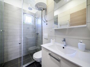 Huis (Two Bedroom Holiday Home with Swimmin) | Badkamer | Een douche, handdoeken