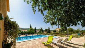 A swimming pool with two sun loungers and a garden area. - Holiday Home Rokoko (Sibenik)