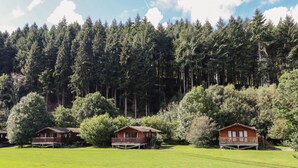 Une rangée de cabanes avec une forêt en arrière-plan.