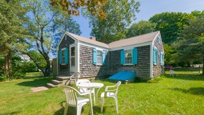 Une maison à deux étages avec un porche et une petite terrasse.