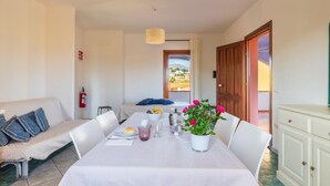 A dining area with a table set for two, a fire extinguisher, and a view of the outside.