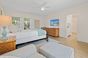 A bedroom with a bed, a dresser, a television, and a ceiling fan. - Amazing Oceanfront View/location - Hot Tub - Multiple Primary Bedrooms (Oceanside)