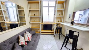 A living room with a grey sofa, black chairs, and white tiled flooring. - Leblon Comfort Suite (Rio de Janeiro)
