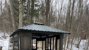 A rustic wooden gazebo with a metal roof, a metal table, and a metal bench. - Rustic Villa | 3 Bedrooms, Fireplace, Pet-Friendly & Near Lac Maskinongé (Saint-Gabriel-de-Brandon)