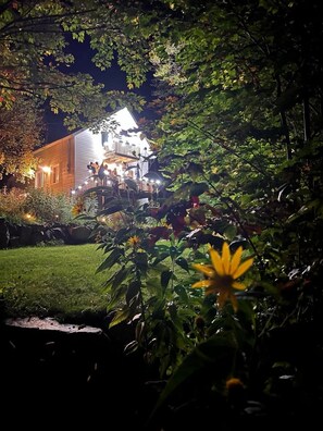 Une maison dotée d’un balcon, entourée de verdure et agrémentée d’une pelouse bien entretenue.