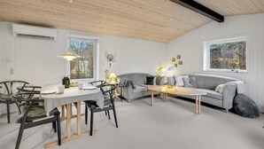 A cozy living room with a dining area, featuring a wooden ceiling, white walls, and large windows. - 3 bedroom lovely home in Hurup Thy (Hurup Thy)