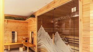 A wooden sauna with benches, a bench with a towel, and a glass door with the name 'ZIRBENSAUNA'. - Apartment Catrin – Hochzillertal/Hochfügen Ski Area, Sauna, EV Charging, Mountain Views (Ried im Zillertal)