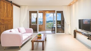 Una sala de estar moderna con un sofá rosa, una mesa de centro de madera y un televisor sobre un mueble de madera.