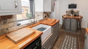 A modern kitchen with a wooden countertop, stainless steel appliances, and a built-in oven.