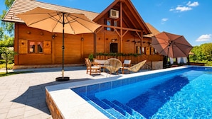 A wooden cabin with a swimming pool, outdoor furniture, and umbrellas. - Rustic Cottage With Heated Pool, Velika Buna, Croatia (Velika Buna)