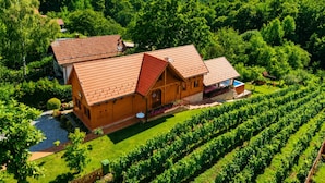 A large wooden house with a red roof, surrounded by a vineyard, and a small swimming pool. - Rustic Cottage With Heated Pool, Velika Buna, Croatia (Velika Buna)