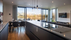 Una cocina moderna con una isla grande, comedor y vistas al exterior.