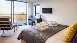 Una habitación de hotel moderna con una cama grande, un escritorio y vistas a un cuerpo de agua.