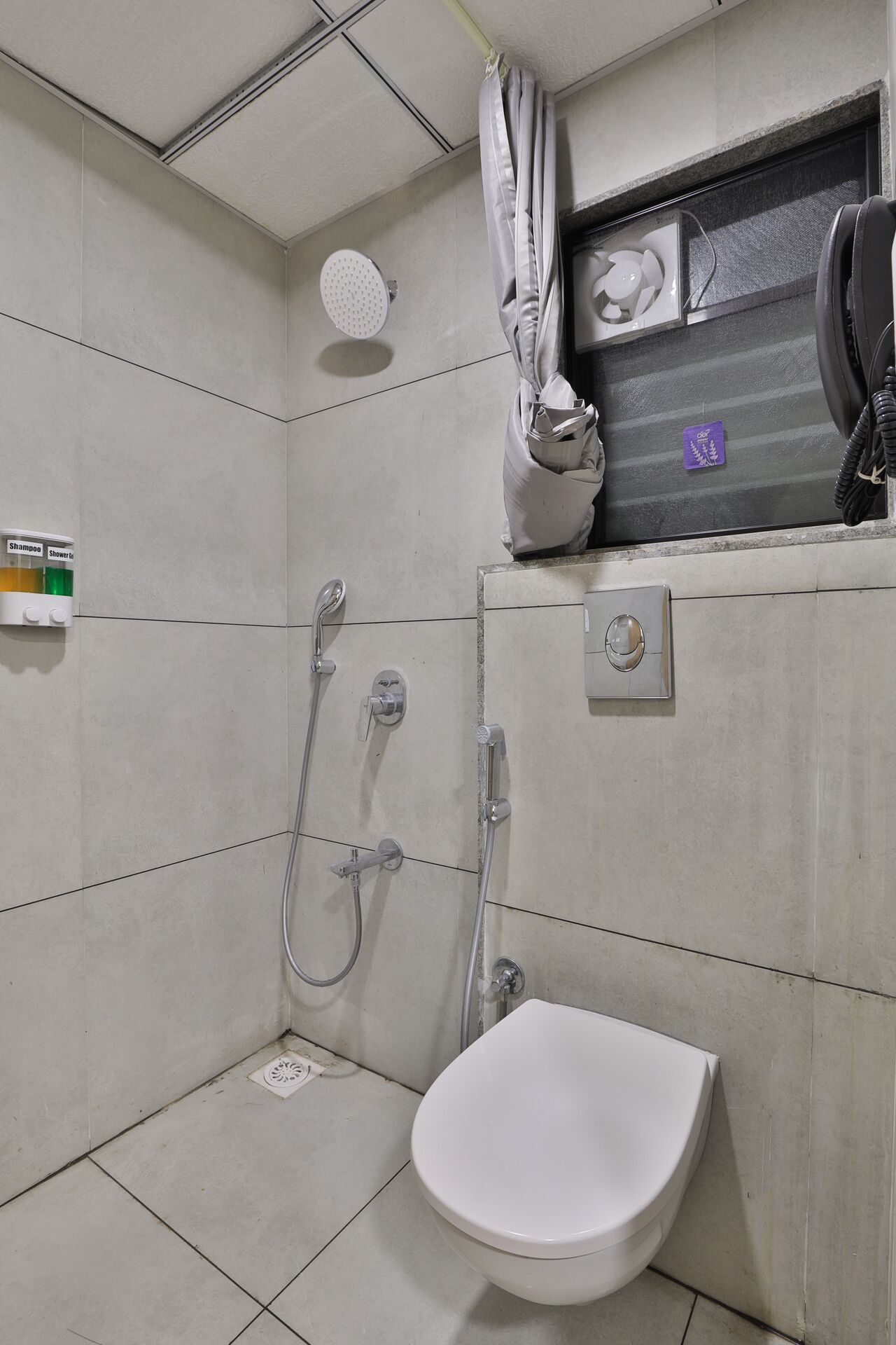 Een badkamer met douche, toilet en wastafel.