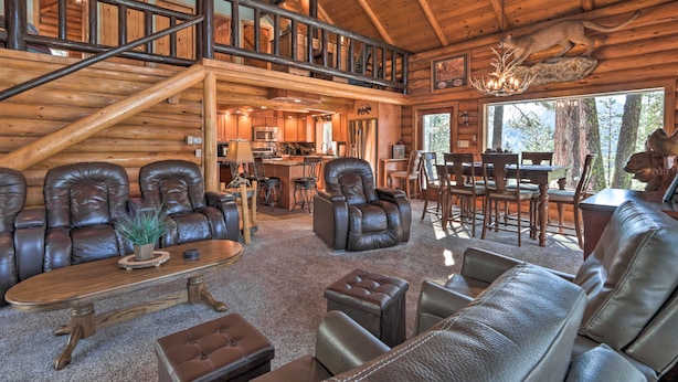 A spacious log cabin interior with leather furniture, a dining area, and a kitchen. - Cascade Cabin w/ Mountain View & River Access (Cascade)