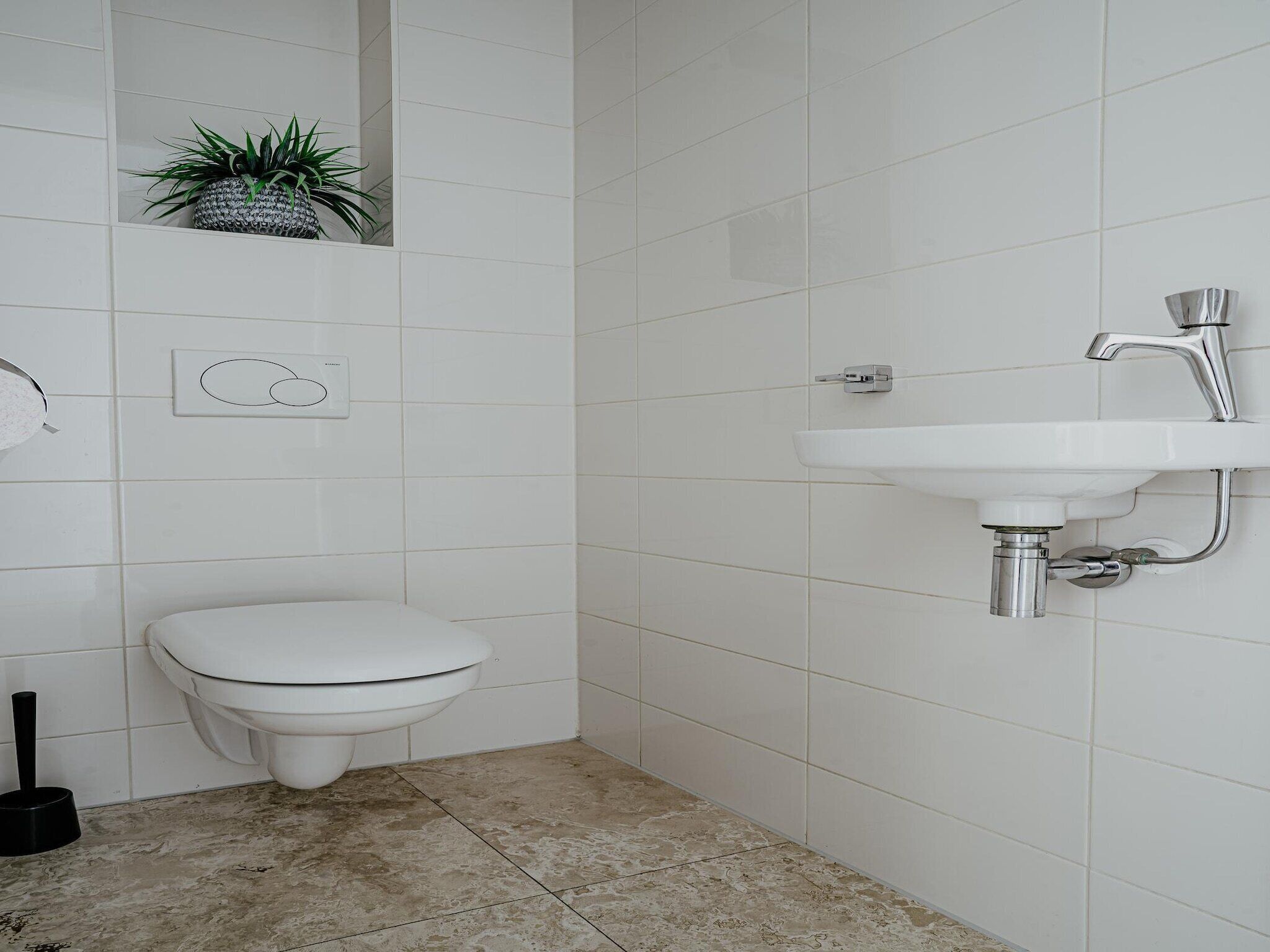 Ein Badezimmer mit Toilette, Waschbecken und Toilettenpapierhalter.