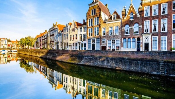 A canal with buildings reflecting on the water.