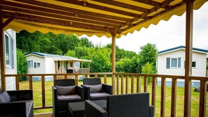 Un espacio de estar al aire libre cubierto con muebles de mimbre y una terraza de madera.