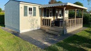 A small, single-story house with a porch and outdoor seating area. - Chalet near Loonse and Drunense Duinen (Udenhout)