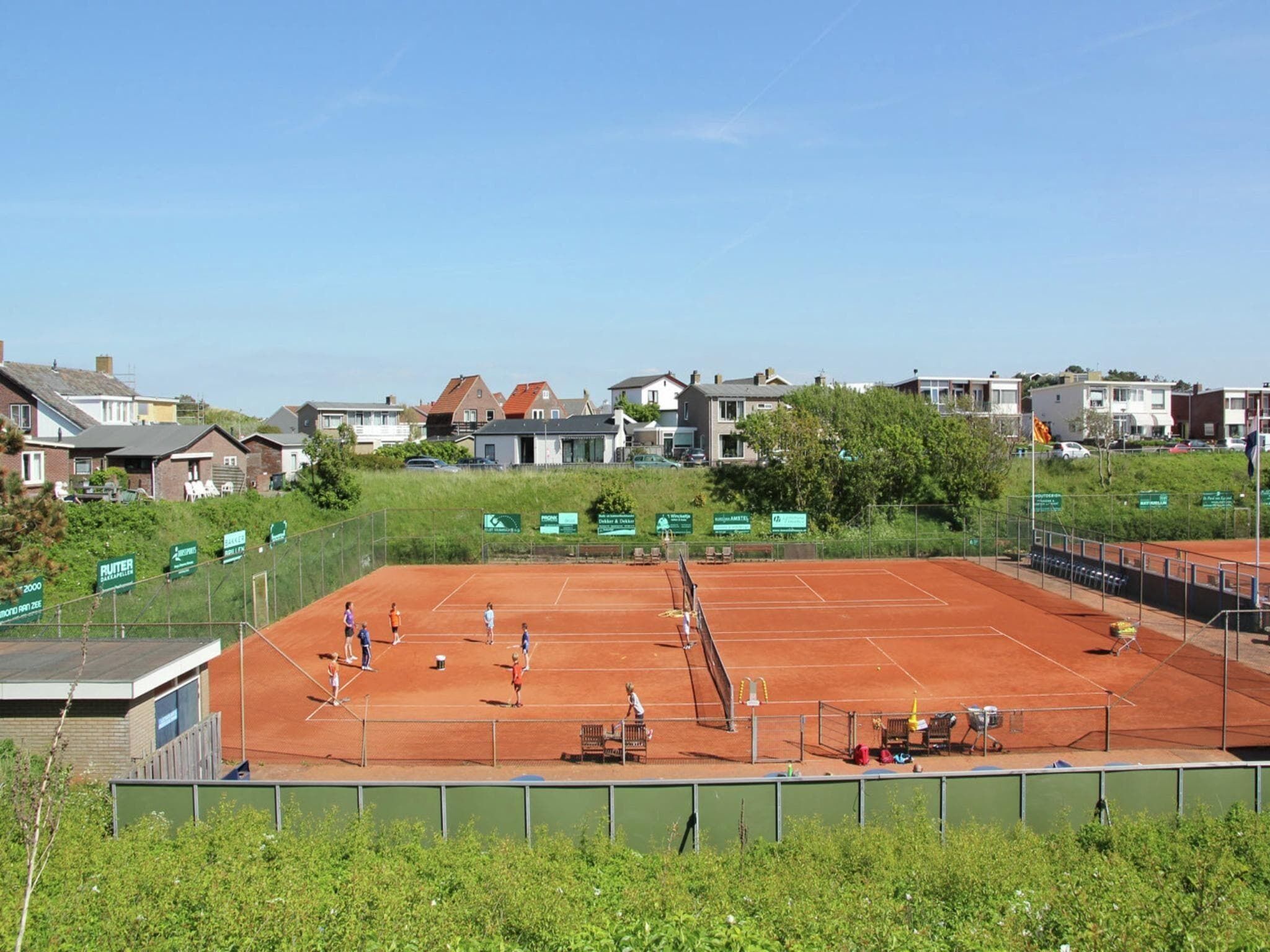 Un court de tennis entouré d’immeubles d’habitation.