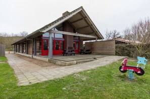 A small building with a red door and a covered patio area.