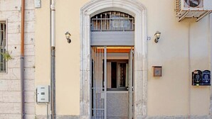 A building entrance with a double door, a small balcony, and a mailbox. - Belvilla by OYO Casa Bella (SIRACUSA)