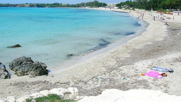A beach with clear turquoise water, sandy shore, and some rocks. - Belvilla by OYO Casa Bella (SIRACUSA)