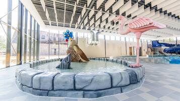 En swimmingpool med en skulptur föreställande en delfin, en skulptur föreställande en flamingo och en skulptur föreställande en fågel.