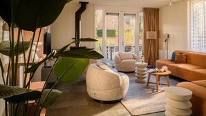 Una sala de estar moderna con un sofá, sillones, una mesa de centro y una chimenea.