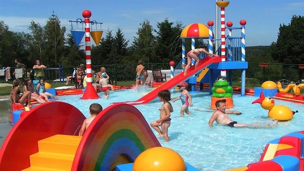 A water park with slides, a pool, and inflatable play structures. - Woodland Lodge Retreat in the Ardennes (Olloy-sur-Viroin)