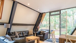 Ein modernes Wohnzimmer mit Sofa, Couchtisch und Blick ins Freie.