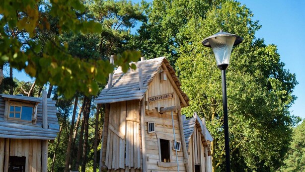Une structure en forme de cabane en bois, sur laquelle est apposée une pancarte indiquant « Molenveld ».